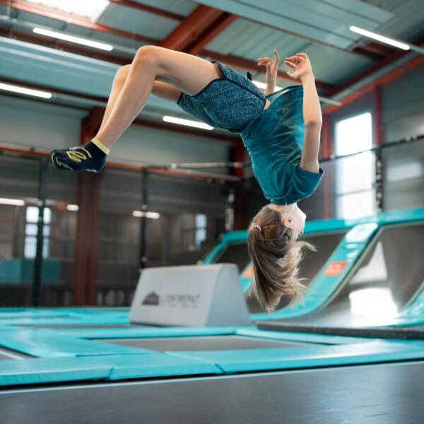 Une fille fait un saut sur les trampolines de l'entrepôt à Bulle